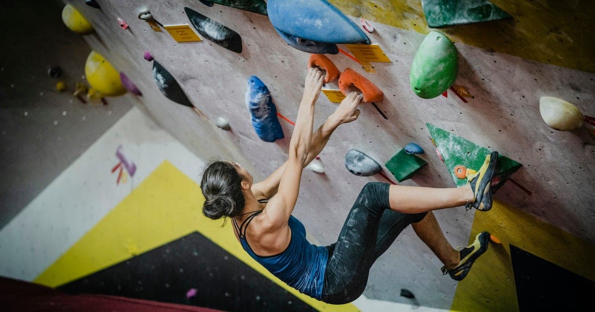 Woman rock climbing inside building